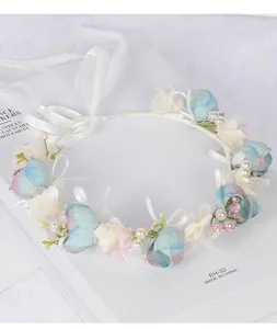 Détails d'une couronne de mariée faite main avec fleurs en soie, perles et ruban blanc