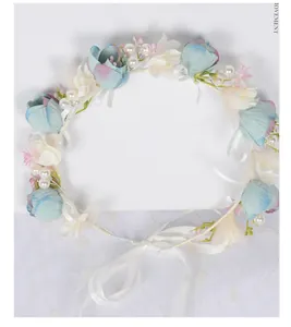 Détail de couronne de mariée avec fleurs en soie bleues, perles et rubans de soie