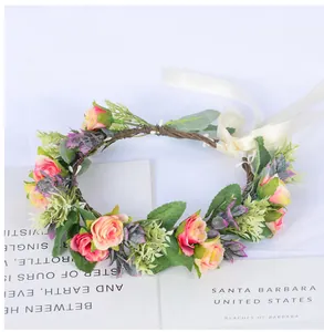 Détail d'une couronne de mariée avec roses artificielles, feuilles et rubans de satin