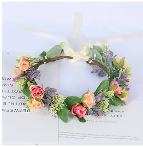 Détail d'une couronne de mariée avec roses roses et rubans de soie sur livre ancien