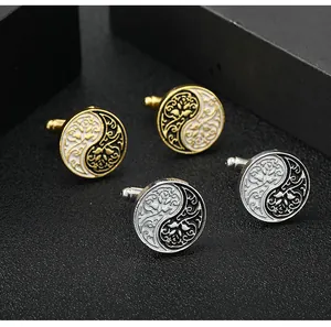 Macro shot of Yin Yang enamel cufflinks with vintage floral cutouts in gold and silver