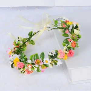 Detail of floral bridal headband with pink and yellow flowers, pearls and satin ribbon