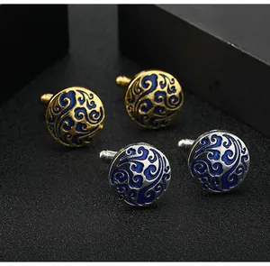 Detail showing round enamel cufflinks with polished silver and gold swirls on black background