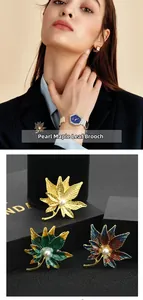Détail macro de broches feuille d'érable en émail avec perle centrale et fini coloré