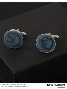 Dettaglio macro di gemelli tondi in marmo blu con chiusura in metallo argentato