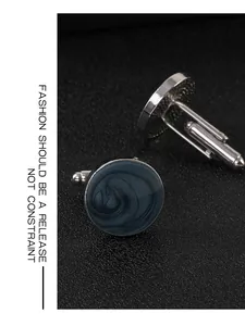 Dettaglio di gemelli tondi in argento con intarsio in marmo grigio e chiusura a T