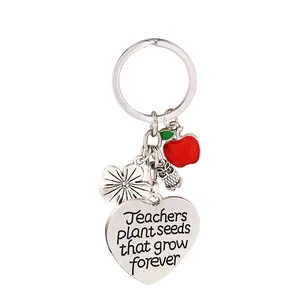 Llavero plateado para profesores con corazón grabado, manzana y búho sobre fondo blanco