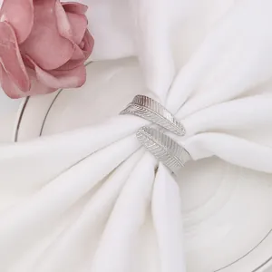 Silver feather napkin ring on white linen napkin for elegant dining table setting