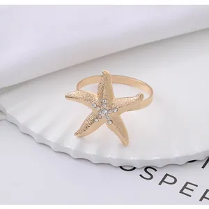 Detailed view of a gold starfish napkin ring with sparkling rhinestones on ceramic