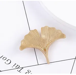 Close-up of golden ginkgo leaf brooch with realistic textures and elegant metal finish