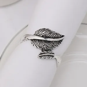 Close-up of vintage silver leaf napkin ring with intricate texture on white cloth