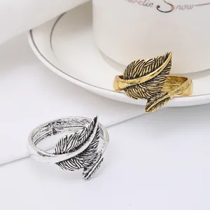 Close-up of vintage feather napkin rings in antique gold and silver with leaf texture