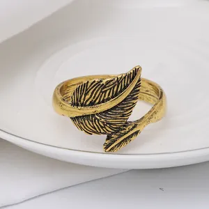 Detailed macro view of vintage gold leaf napkin ring with intricate feather texture