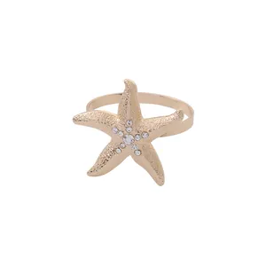 Golden starfish napkin ring with textured finish and sparkling crystal centerpiece