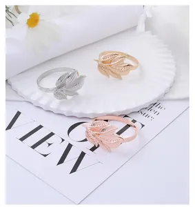 Detailed view of metal leaf napkin rings in gold, silver, and rose gold finishes