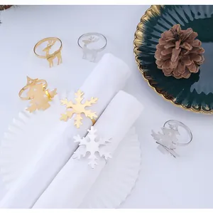 Detalle de servilleteros navideños dorados y plateados con formas de reno y copos de nieve