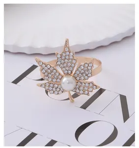 Macro shot of maple leaf napkin ring featuring gold finish with pavé rhinestones and pearl