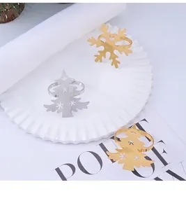 Detalle de servilleteros metálicos en oro y plata con formas de copo y árbol de Navidad