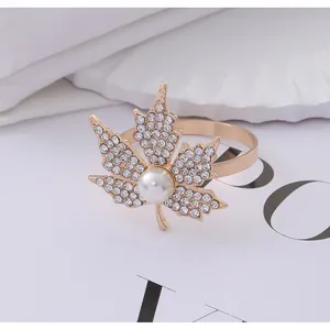 Detailed close-up of golden maple leaf napkin ring with sparkling rhinestones and pearl