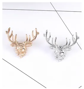 Detail of vintage elk head brooches in gold and silver finish with textured antlers
