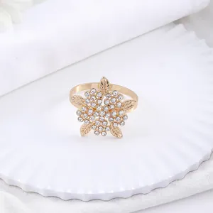 Elegante portatovagliolo dorato con strass scintillanti su piatto in ceramica