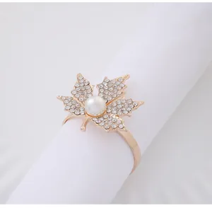 Detailed view of a golden maple leaf napkin ring with sparkling rhinestones and pearl