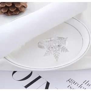 Détail d'un rond de serviette en métal argenté flocon de neige sur une assiette blanche