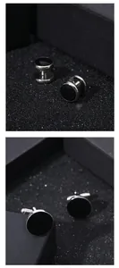 Detail of round black enamel cufflinks and screw-back ear studs for men in polished silver metal