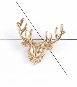 Detailed close-up of a vintage golden elk head brooch with textured antlers and metallic finish