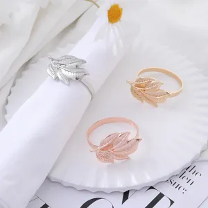 Elegant leaf-shaped metal napkin rings in gold, silver, and rose gold for table decor