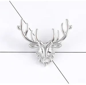 Macro shot of silver deer head brooch showing intricate metal textures and antler details