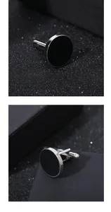 Detail view of round black enamel cufflinks with silver metal base on luxury display