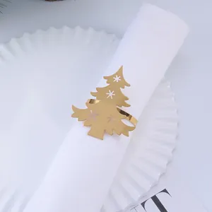 Servilletero dorado con forma de árbol de Navidad y copos de nieve sobre servilleta