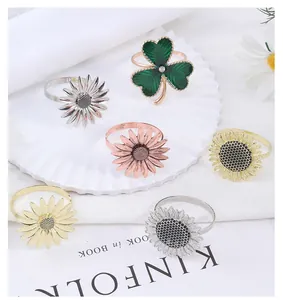 Close-up of metallic sunflower and clover napkin rings in silver, gold, and rose gold finishes