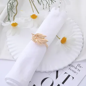 Elegant gold leaf napkin ring on white linen set for creative luxury table setting decoration