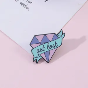 Detailed close-up of diamond-shaped enamel brooch featuring blue ribbon with get lost text
