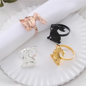 Set of four bunny napkin rings in gold, silver, black, and rose gold on a ceramic plate