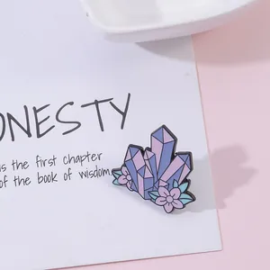 Detail of floral crystal enamel brooch with purple and blue gemstones on display card