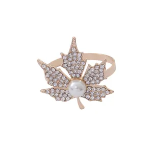 Golden maple leaf napkin ring with sparkling crystals and a central white pearl detail
