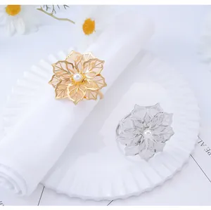 Detailed view of hollow flower metal napkin rings with white pearls in gold and silver
