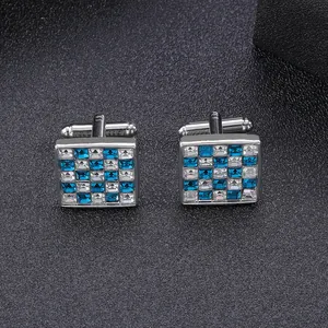 Detail of square cufflinks with blue and white crystals in a checkerboard pattern