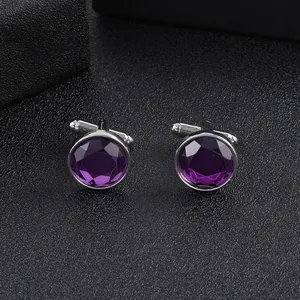 Macro shot of silver cufflinks featuring faceted round purple crystals on black background