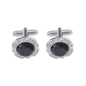 Detailed macro view of silver cufflinks with blue oval stone and rhinestone border