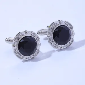 Detail of silver cufflinks with centered black faceted stone and sparkling white crystals