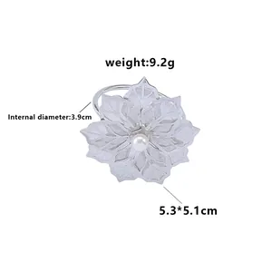 Silver metal mesh flower napkin ring with a white pearl center on a white background