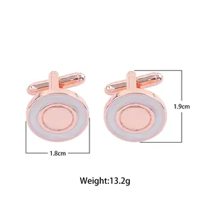 Détail gros plan de boutons de manchette ronds or rose avec incrustation émail blanc