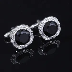 Macro shot of silver cufflinks with black crystal and small white diamonds detail
