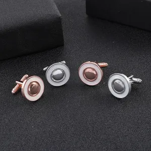 Détail de boutons de manchette géométriques ronds en or rose et argent avec émail blanc
