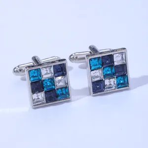 Detailed macro view of square cufflinks with blue and white crystals in silver metal base