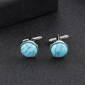 Close-up of round sky blue stone cufflinks with black marble texture and silver base